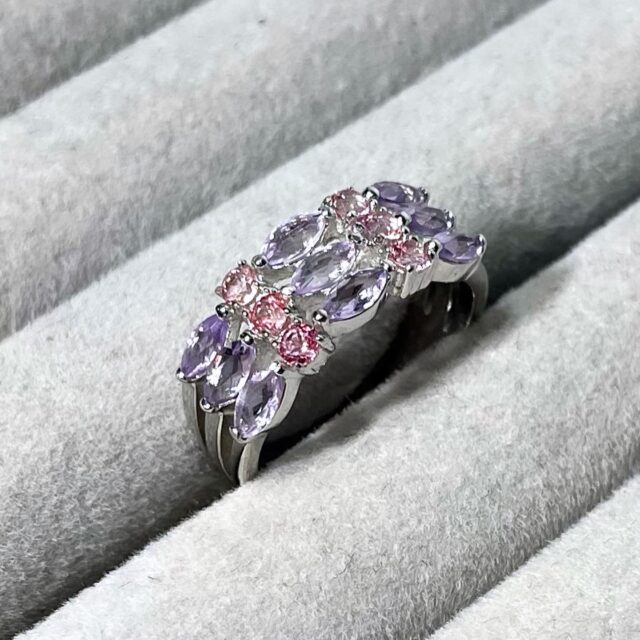 A silver ring with amethysts and pink spinels