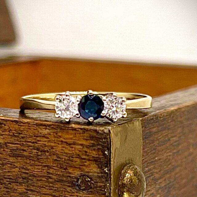 A gold ring with a sapphire and diamonds
