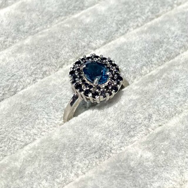 A silver ring with a topaz and black tourmalines