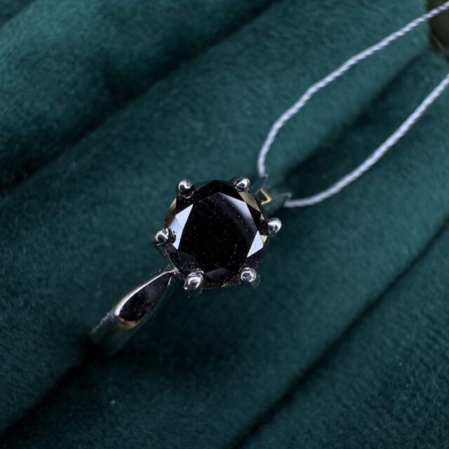 A silver ring with a black diamond