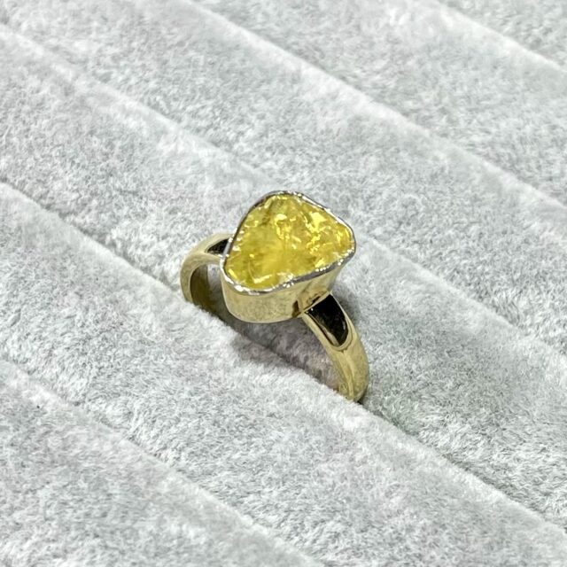 A silver ring with a yellow diamond